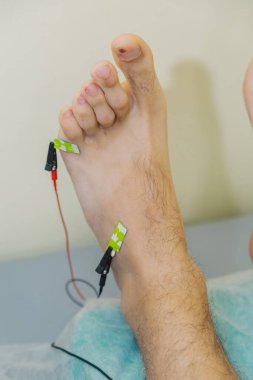 Klinikte bacağında sensörler olan bir adam..