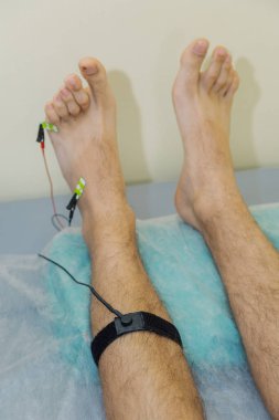 Klinikte bacağında sensörler olan bir adam..