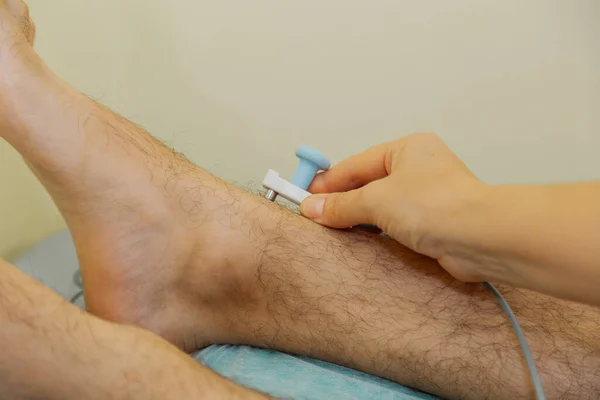 Mulher médico coloca um sensor na perna pacientes. — Fotografia de Stock