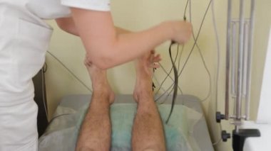 Kadın doktor hastaların bacaklarına lens takıyor.