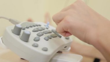 Kadın doktor sinir tepkilerini ölçmek için bir cihaza tıklıyor..