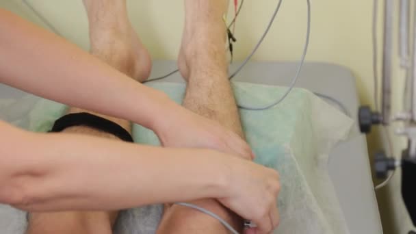Médica fêmea atribui contatos com as pernas dos pacientes. — Vídeo de Stock