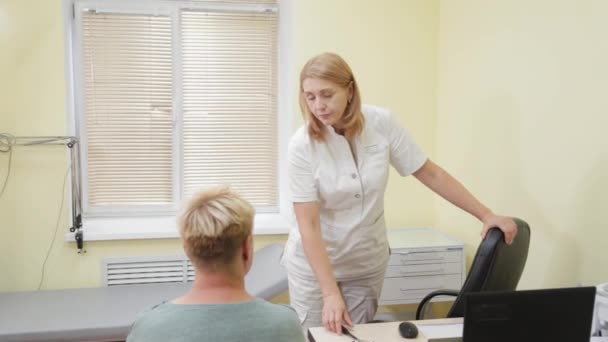 Vrouwelijke neuroloog onderzoekt een patiënt in een privé kliniek. — Stockvideo