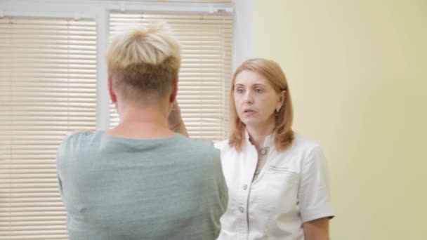 Žena neurologka vyšetřuje pacienta na soukromé klinice. — Stock video