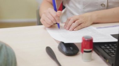 Kadın doktor bir hastaya reçete yazar..