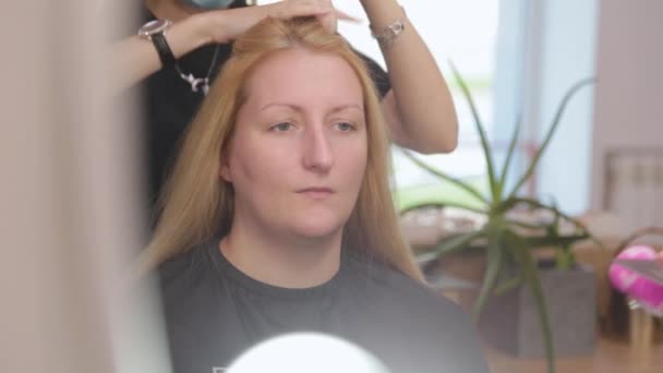 Красивая женщина делает прическу в парикмахерской. — стоковое видео