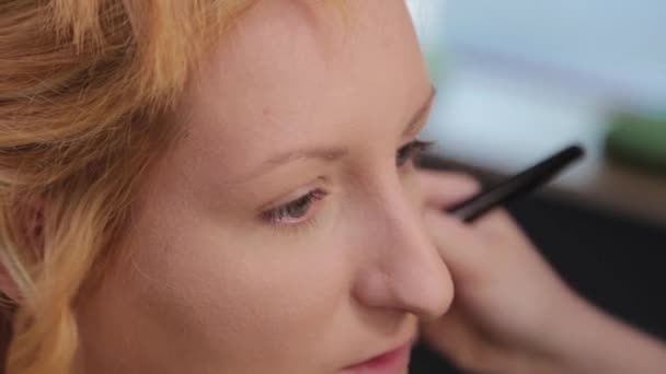 Hermosa mujer haciendo maquillaje en un salón de belleza. — Vídeos de Stock