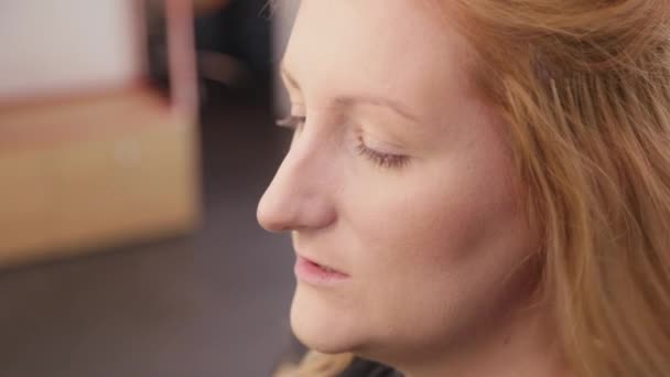 Hermosa mujer haciendo maquillaje en un salón de belleza. — Vídeos de Stock