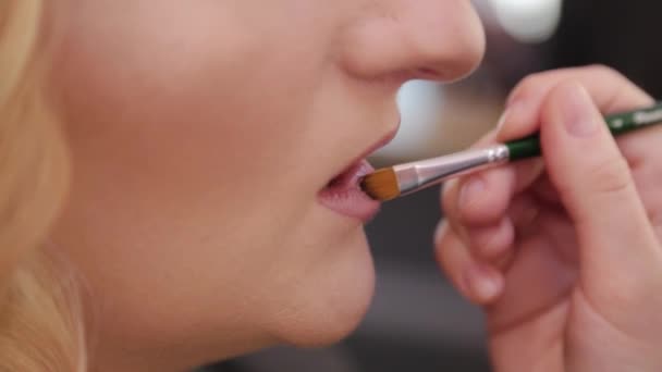 Hermosa mujer haciendo maquillaje en un salón de belleza. — Vídeo de stock