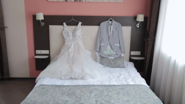 Красивая стильная свадебная куртка и платье на кровати. — стоковое видео