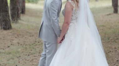 Çok güzel gelin ve damat yazın ormanda yürüyor..