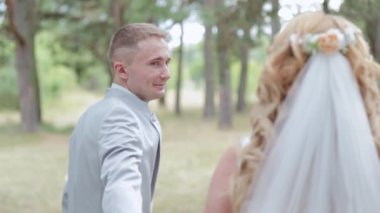 Çok güzel gelin ve damat yazın ormanda yürüyor..