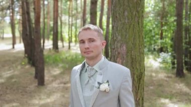 Ağacın yanındaki ormanda yaka çiçekli yakışıklı damat..