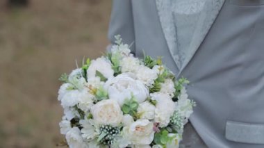 Ağacın yanındaki ormanda yaka çiçekli yakışıklı damat..