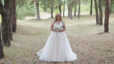 Yeşil yaz ormanında düğün buketi olan gelin.