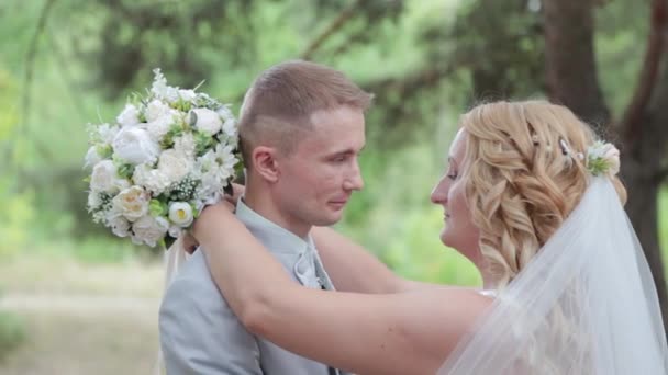 Superbe mariée et marié embrassant et embrassant dans la forêt d'été. — Video