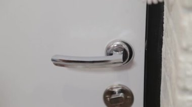 Ofisteki beyaz ahşap kapıyı açan ve kapatan kadın. Kapı kolunu tutuyorum. Tam HD video hareketi