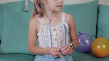Mutlu kız dairede balon patlatıyor..