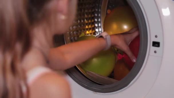 Gadis bahagia mengeluarkan balon dari mesin cuci.. — Stok Video