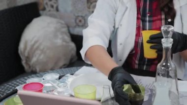 Evde kimyasal deneyler yapan genç bir kadın..
