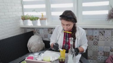Evde kimyasal deneyler yapan genç bir kadın..
