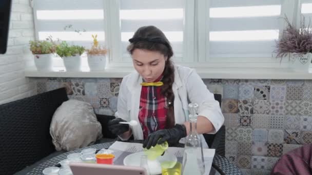 Молодая женщина проводит химические эксперименты дома. — стоковое видео
