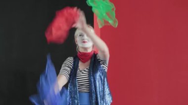 Kadın palyaço sahnede hokkabazlık yapıyor.