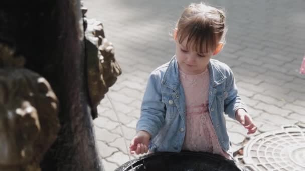 Маленька дівчинка на питному фонтані в парку . — стокове відео