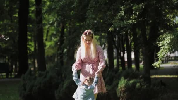 Giovane madre che gira intorno alla figlia nel parco. — Video Stock