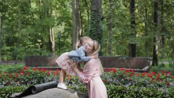 Happy young mother with little daughter having fun in the park. — Stock Video