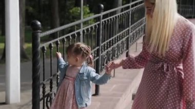 Küçük mutlu kız, korkulukların yanında yürür..