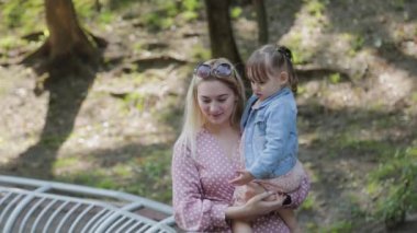 Küçük mutlu kız, korkulukların yanında yürür..