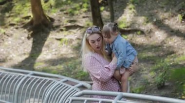 Küçük mutlu kız, korkulukların yanında yürür..