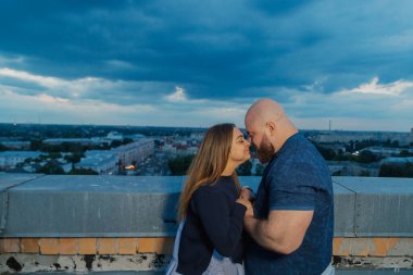 Güzel ve mutlu aşıklar çatıda sarılıyorlar.