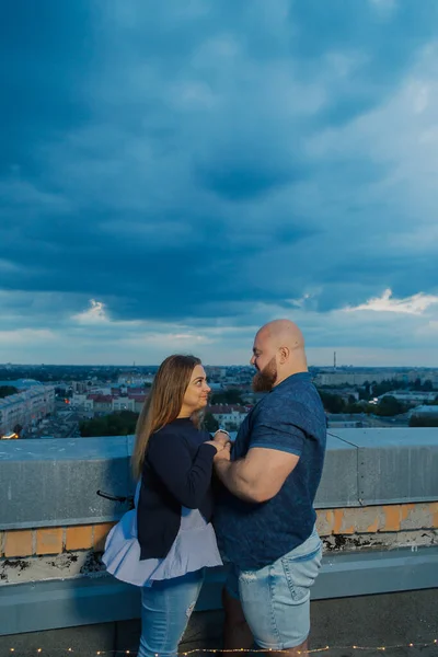 Mooie en gelukkige minnaars op het dak knuffelen. — Stockfoto