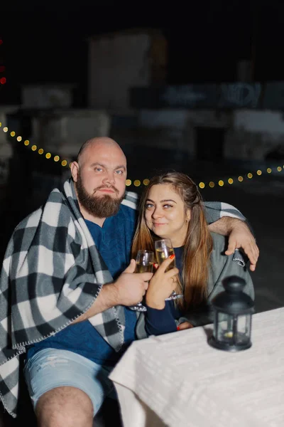 Liefhebbers op het dak zitten aan een tafel met champagne. — Stockfoto