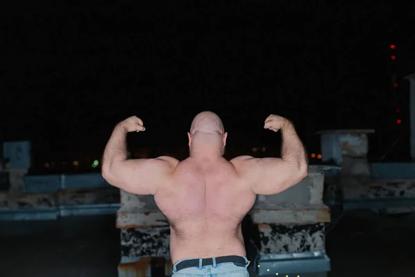 Big bearded bodybuilder on the rooftop in the evening. — Stock Photo, Image