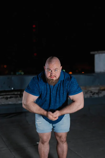 Big bearded bodybuilder on the rooftop in the evening. — Stock Photo, Image