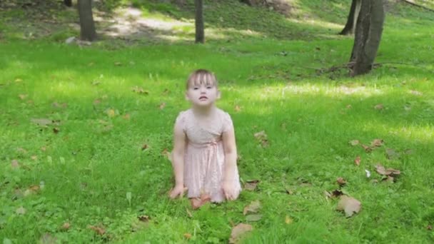 Güzel küçük kızım çimenlerde oturuyor.. — Stok video