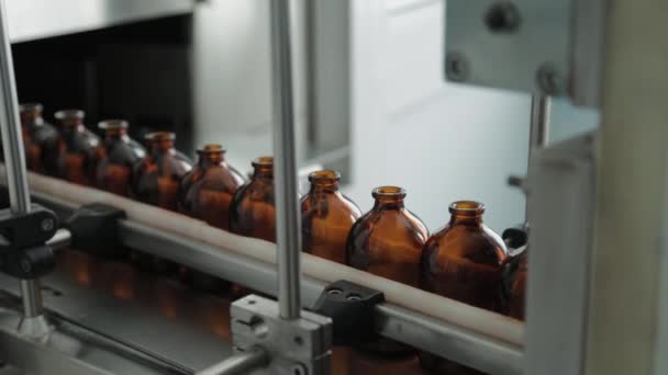 医薬品製造工場のコンベアベルト上の茶色の医療用バイアル. — ストック動画