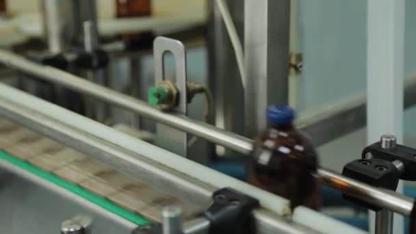 Bruna medicintekniska injektionsflaskor på ett transportband vid en läkemedelsfabrik. — Stockvideo