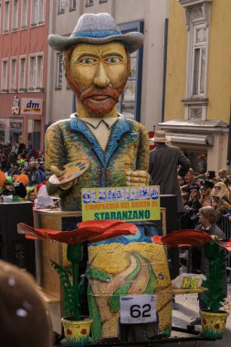 Villach, Avusturya - 21 Şubat 2020: Villach 'taki geleneksel karnaval alayında büyük bir kukla caddede yürüyor.