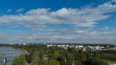 Po Nehri ve Cremona şehrinin manzaralı manzarası. Parlak bir günde yemyeşil ve kentsel gelişimi gösteriyor. Uçsuz bucaksız mavi gökyüzü altında tüylü beyaz bulutlarla dolu.