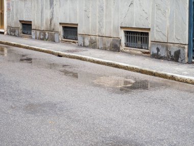 Şehir Caddesinde Yağmurdan Sonra Izgara Pencerelerle Gri Gökler ve Bina Cephesi Yansıtan Islak Kale