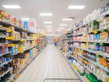 Cremona, İtalya. 10 Eylül 2025. Geniş süpermarket koridoru. Paketlenmiş gıda ürünleri sıraları sergileniyor.