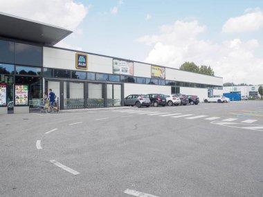 Cremona, İtalya - 11 Eylül 2025 İtalya 'daki Modern Aldi İndirimli Süpermarketin Dış Görünümü Müşterilerin Girdiğini ve Açık Mavi Gök Altındaki Otoparka Park Ettiğini ve Dağılmış Bulutları Gösteriyor