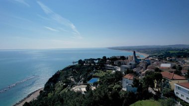 Havadan bakıldığında Conero Riviera 'nın, Numana' ya tepeden bakan Haç Sığınağı 'yla birlikte sergilenmesi, İtalya' nın Le Marche kentinin çarpıcı sahil şeridini ve manzarasını vurguluyor.