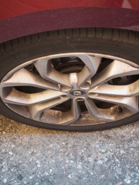 Cremona, İtalya 16 Eylül 2025 Renault Clio V E TECH R.S. Çizgili araba tekerleği ve lastik tozlu asfalt bir yolda kirli alaşımlı kenar, kırmızı kaporta ve lastik izlerini gösteriyor.