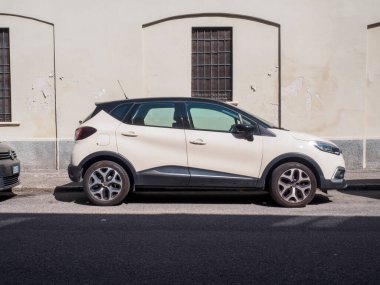 Cremona, İtalya 16 Eylül 2025 Renault Captur kavşağı bir şehir caddesinde, güçlü bir güneş ışığı altında, fildişi ana renk ve siyah çatısı ile iki renk gövdesini sergiliyor