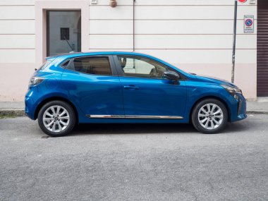 Cremona, İtalya 16 Eylül 2025 Mavi 2023 Renault Clio V E Tech tam hibrit tekno araba şehir caddesinde park halinde, dinamik tasarımı ve modern elektrikli hatchback ve